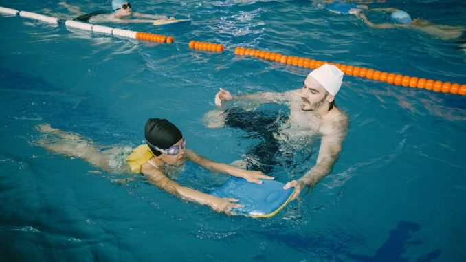 coach-teaching-kid-indoor-swimming-pool-how-swim-dive-swimming-lesson-kids-development_1157-49330